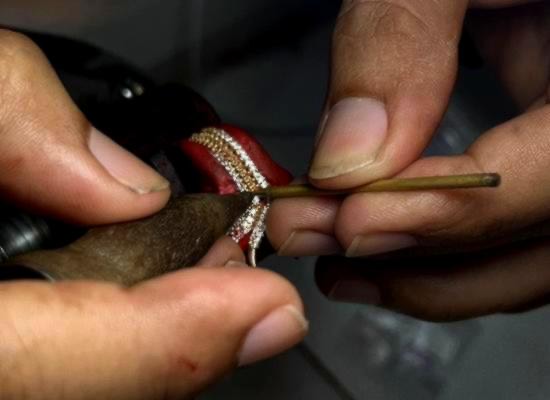 Close view of a jeweler working on a stone-set ring